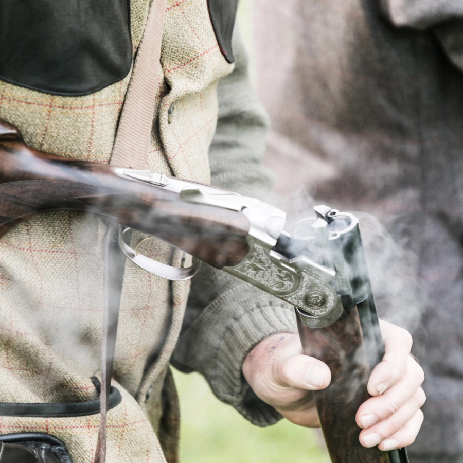 A shot breaks a smoking rifle on a hunt
