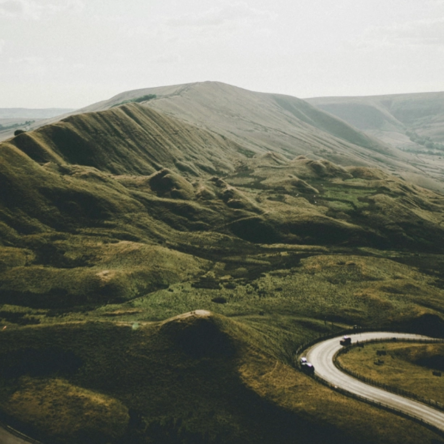 A road winds through the awesome Peak District mountains